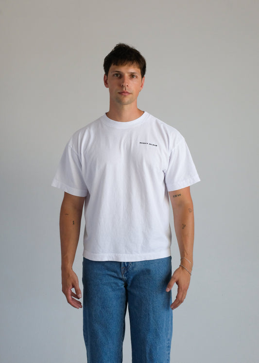 Person wearing a white t-shirt and blue jeans against a plain background