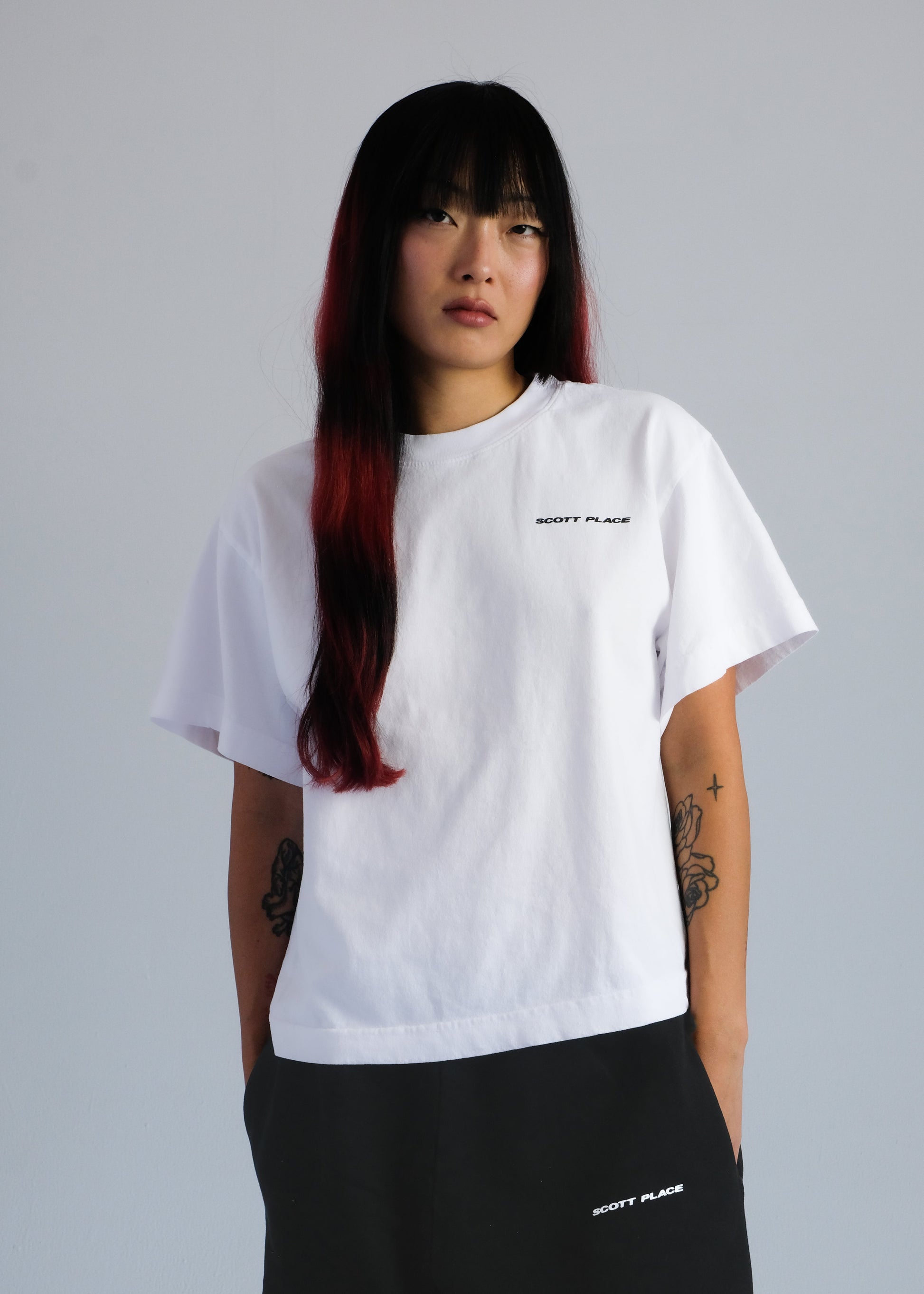 Person wearing a white t-shirt with text on a plain background