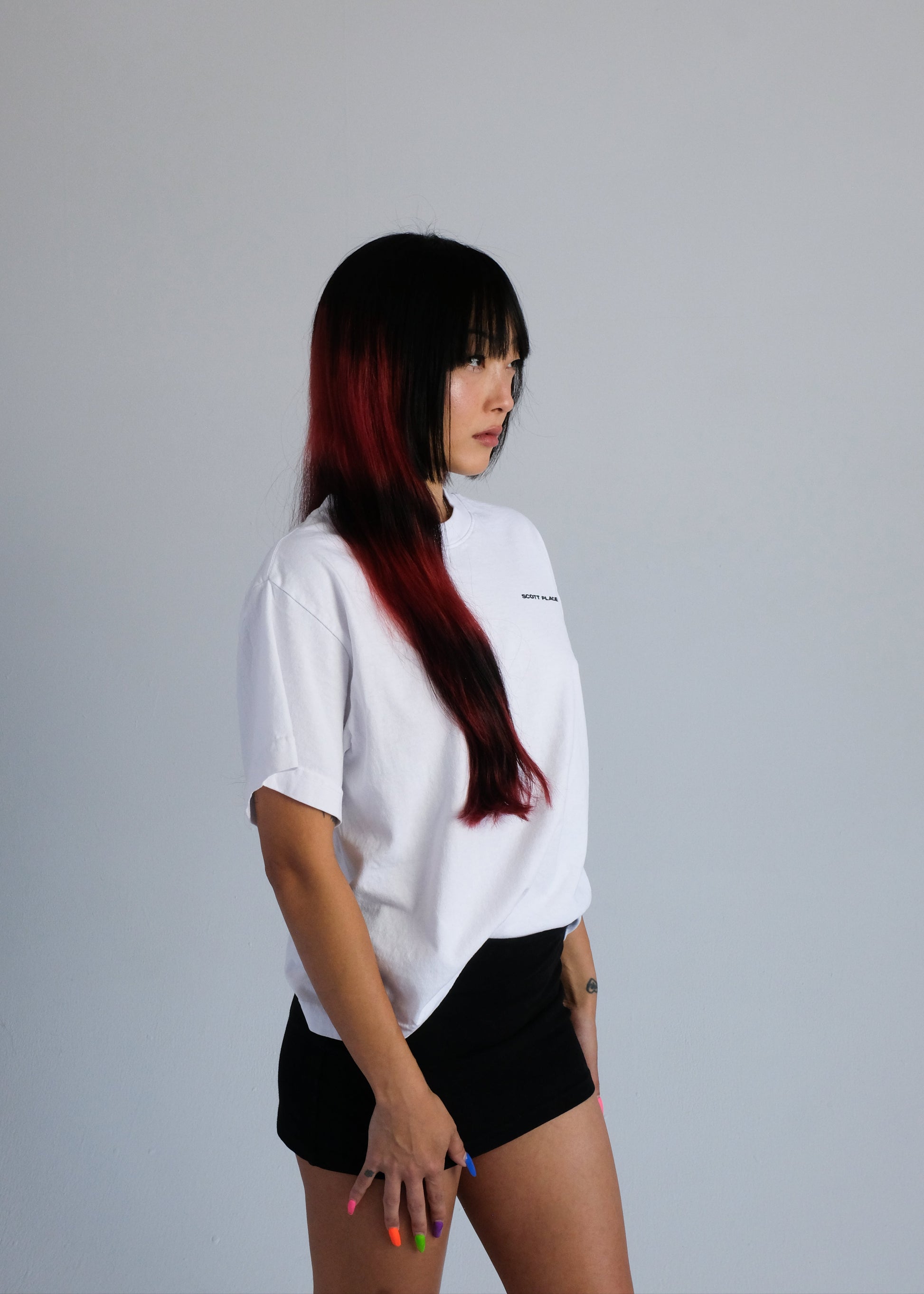 Person wearing a white t-shirt and a black skirt on a plain background
