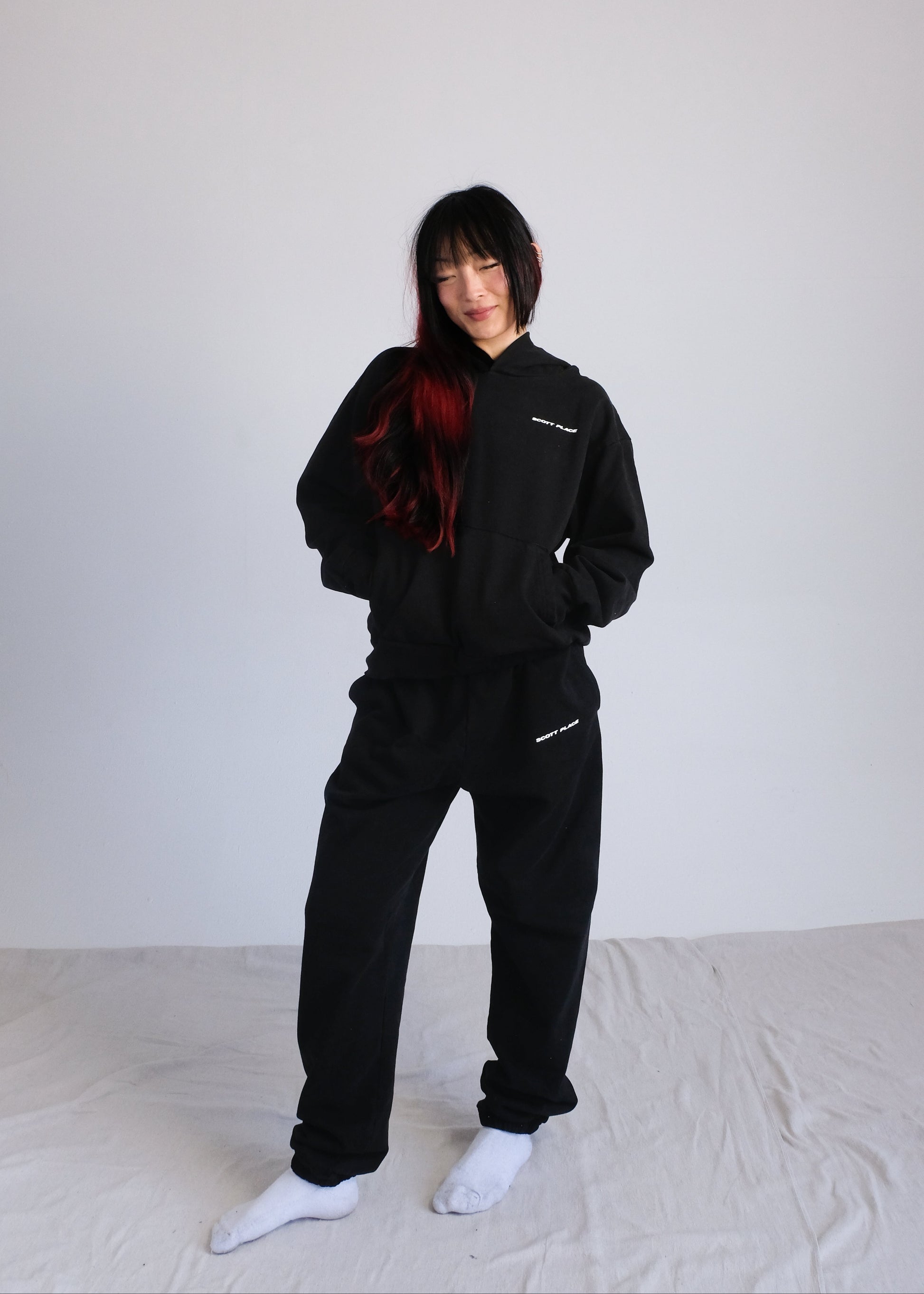 Person wearing a black tracksuit on a white background